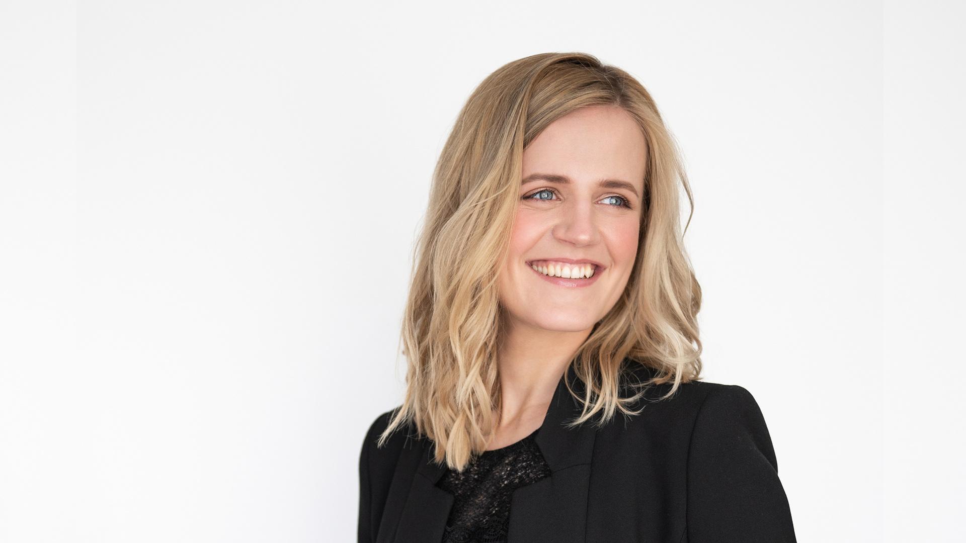 Dirigenten Krista Audere ler och tittar åt sidan.