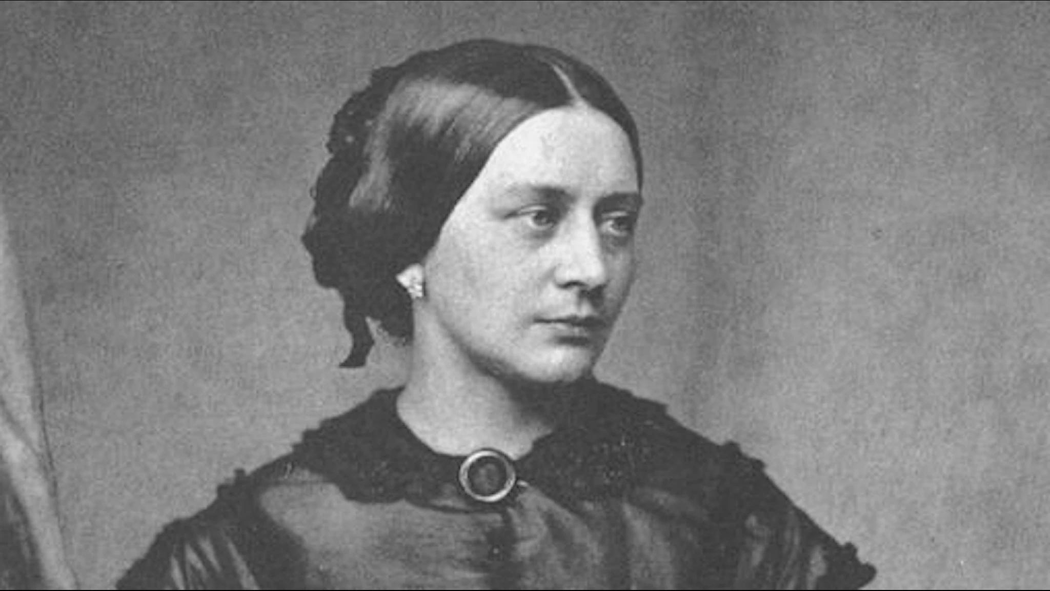 Porträtt av Clara Schumann, hon har mörkt uppsatt hår, vrider lätt på huvudet och man ser ett örhänge.