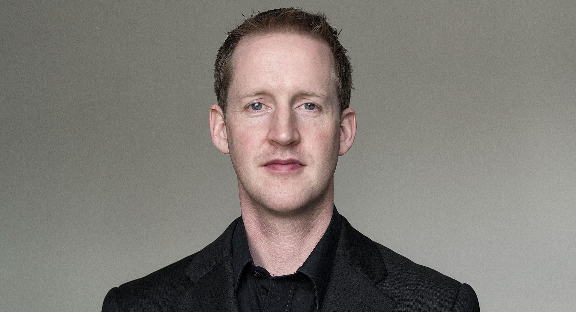 Porträttbild på Justin Doyle i svart skjorta.