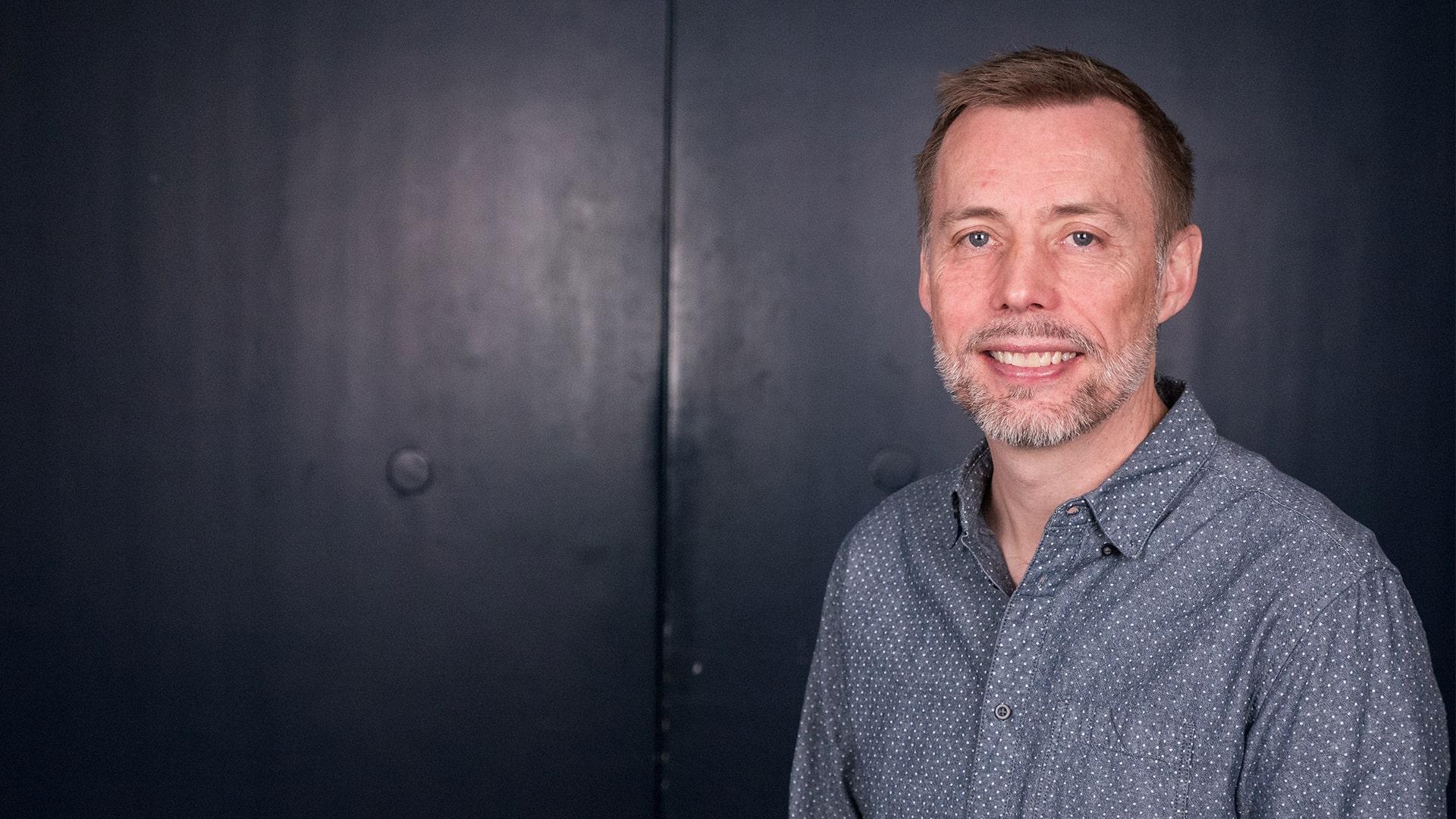 Magnus Wennerberg, Radiokören. Leende man med kort skägg, klädd i grå skjorta med vita prickar.