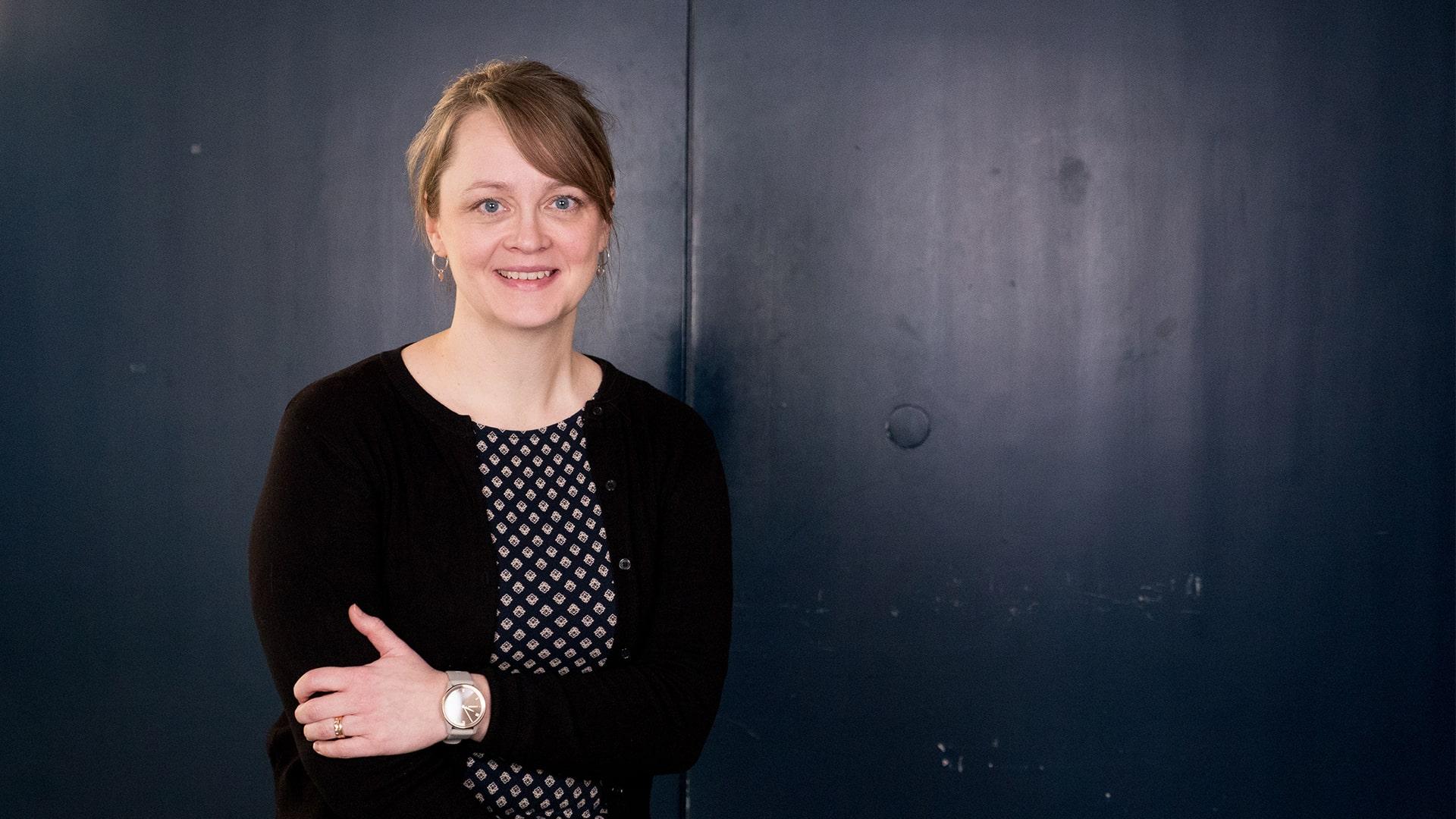 Ida Zackrisson, Radiokören. Kvinna med uppsatt hår och snedlugg tittar in i kameran och ler. Hon har en småmönstrad blus under en svart cardigan.