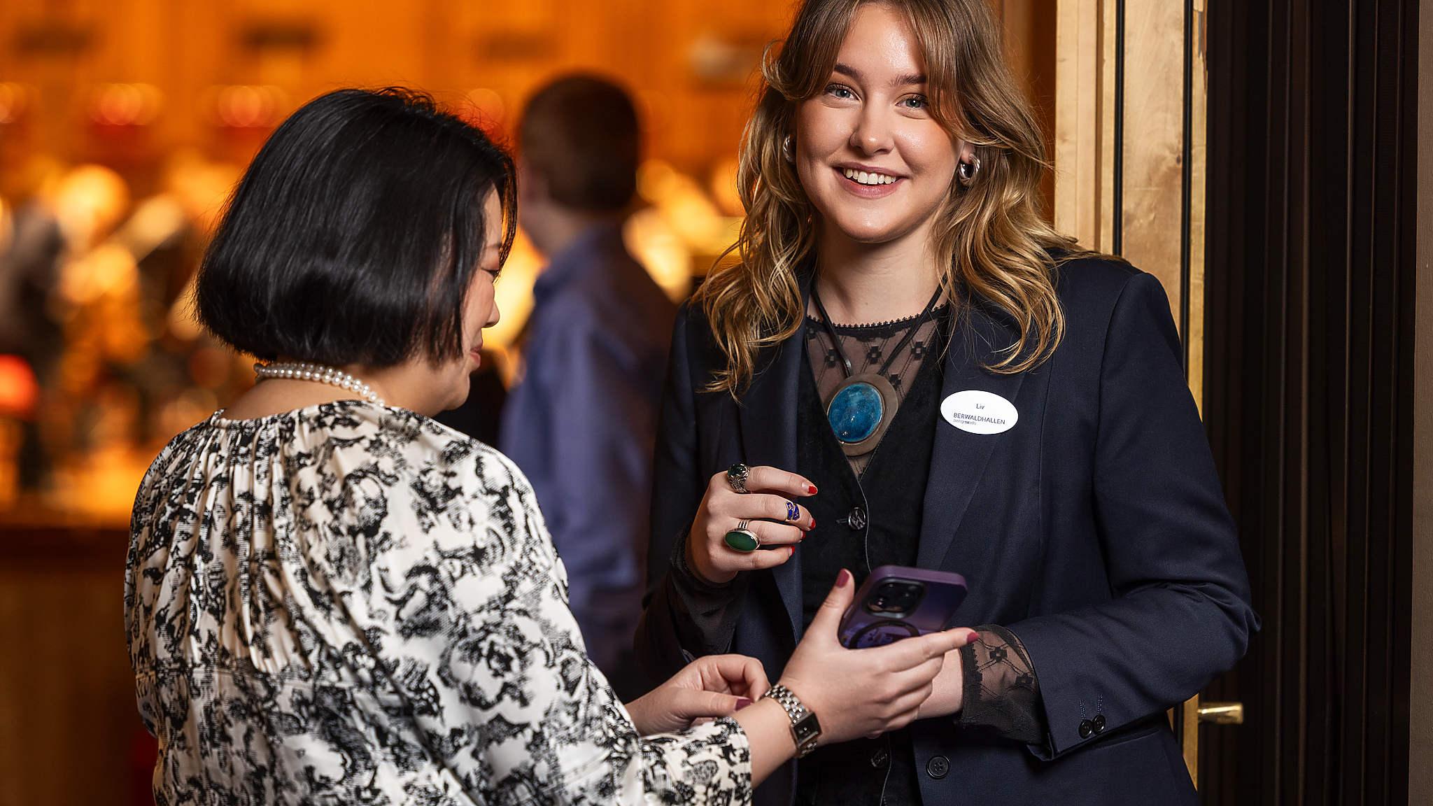 En publikvärd scannar en kvinnas biljett vid entrén till konsertsalen.