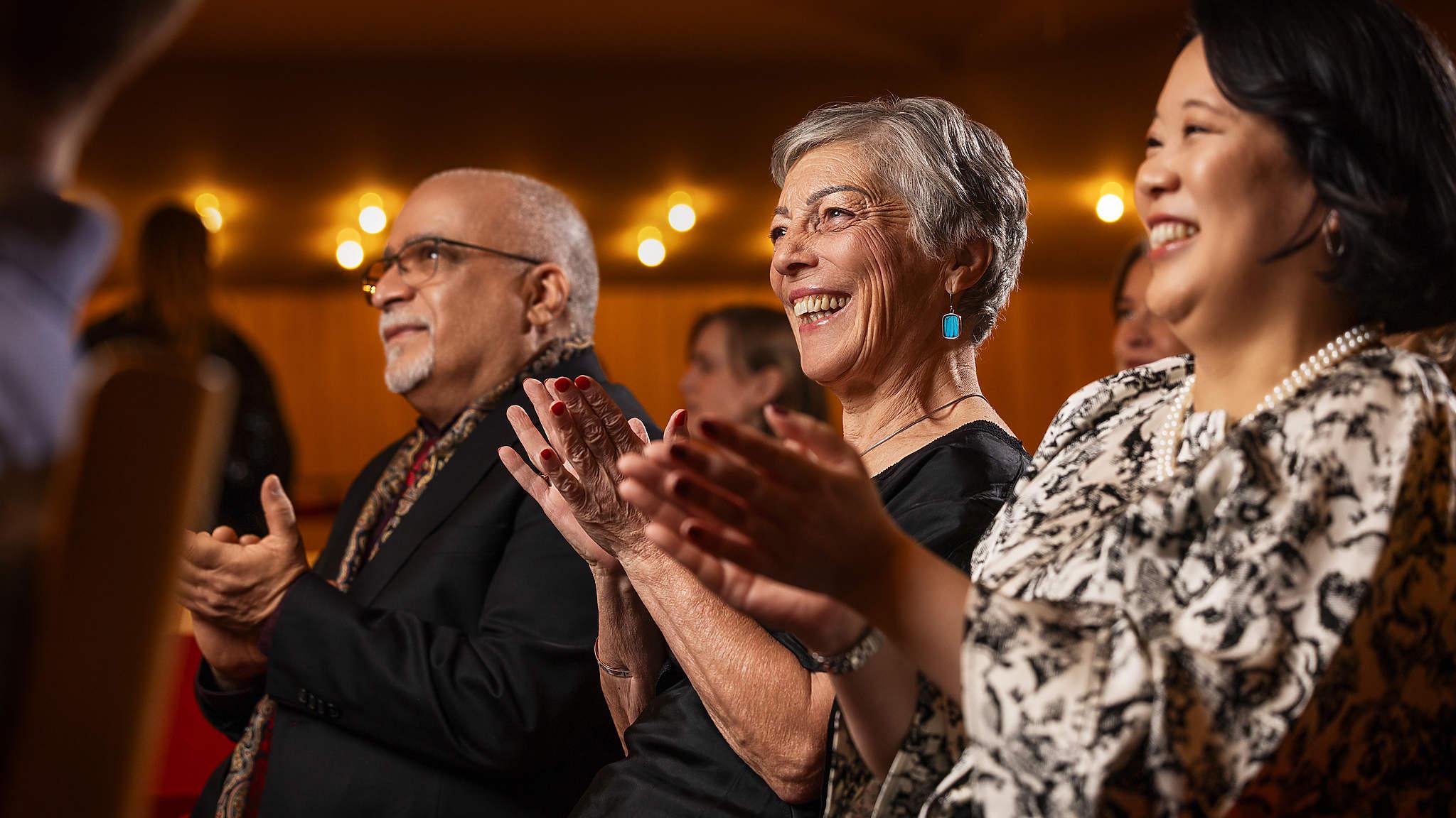 Publik i närbild som applåderar och är glada.