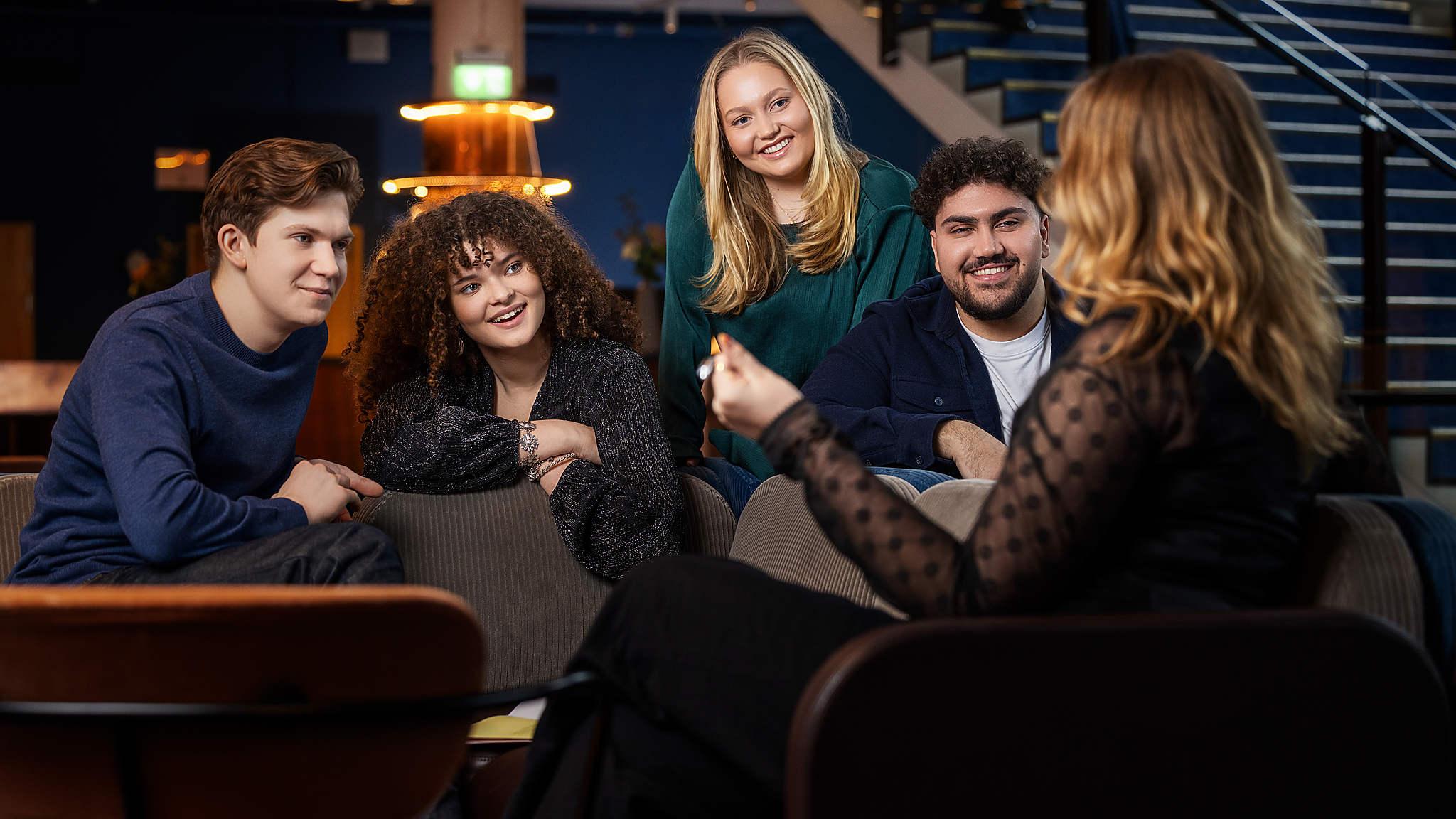 En grupp ungdomar sitter och pratar i foajén i Berwaldhallen.