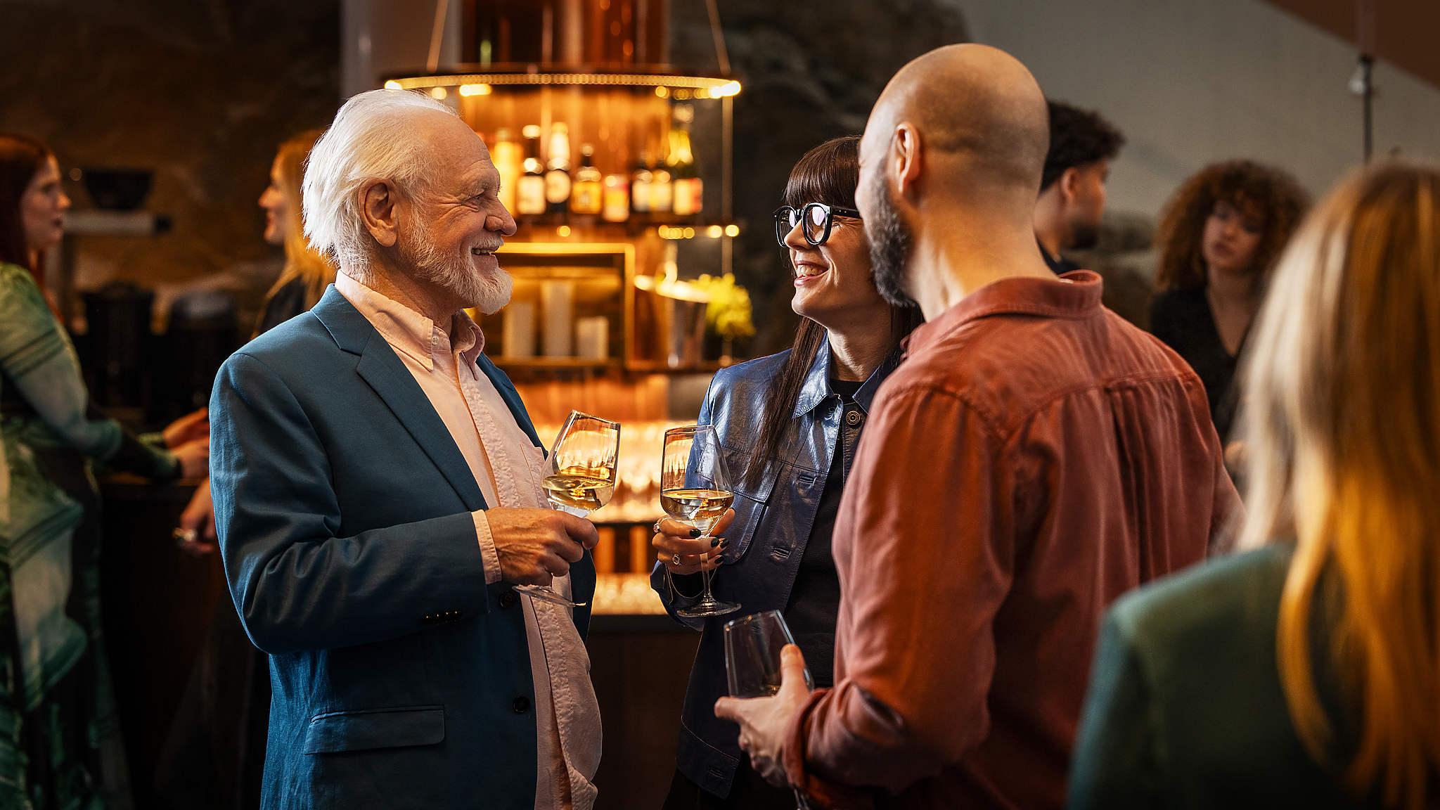 Människor samtalar och dricker vin i foajén i Berwaldhallen