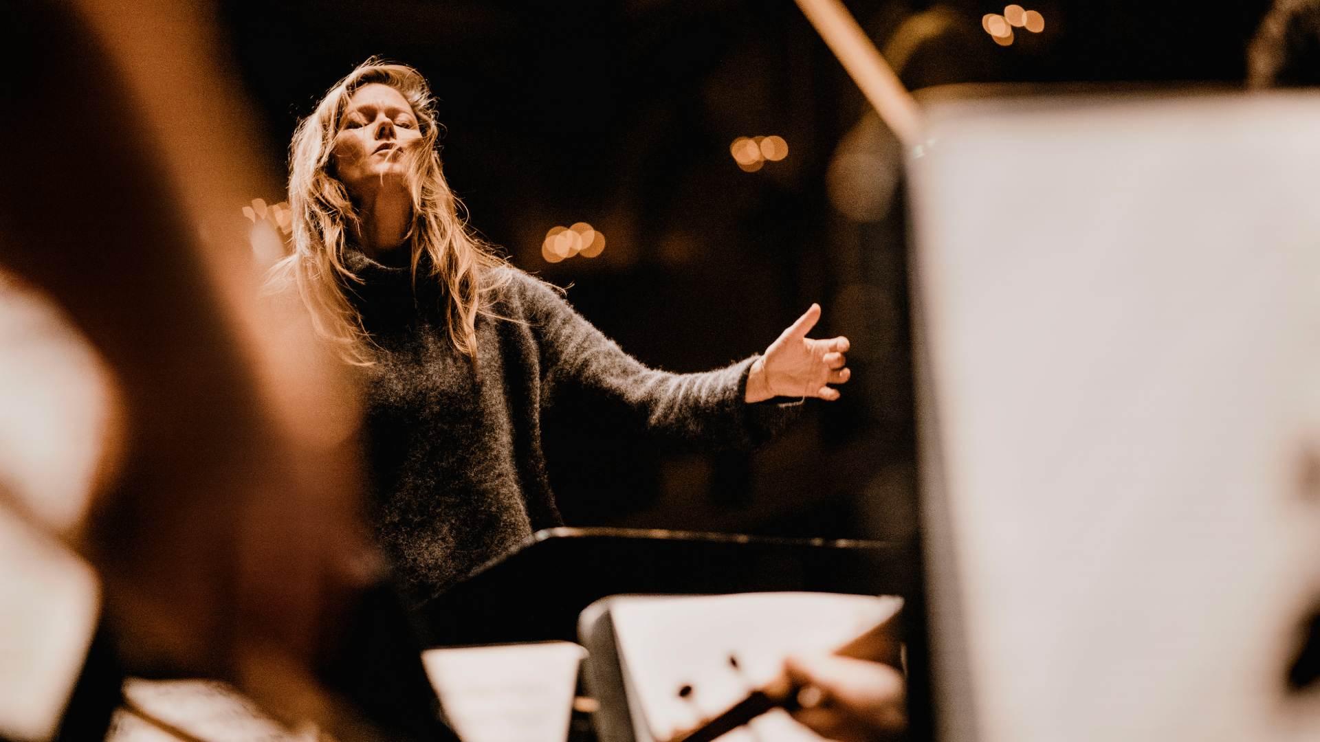 Barbara Hannigan dirigerar. hon bär en stickad polotröja.