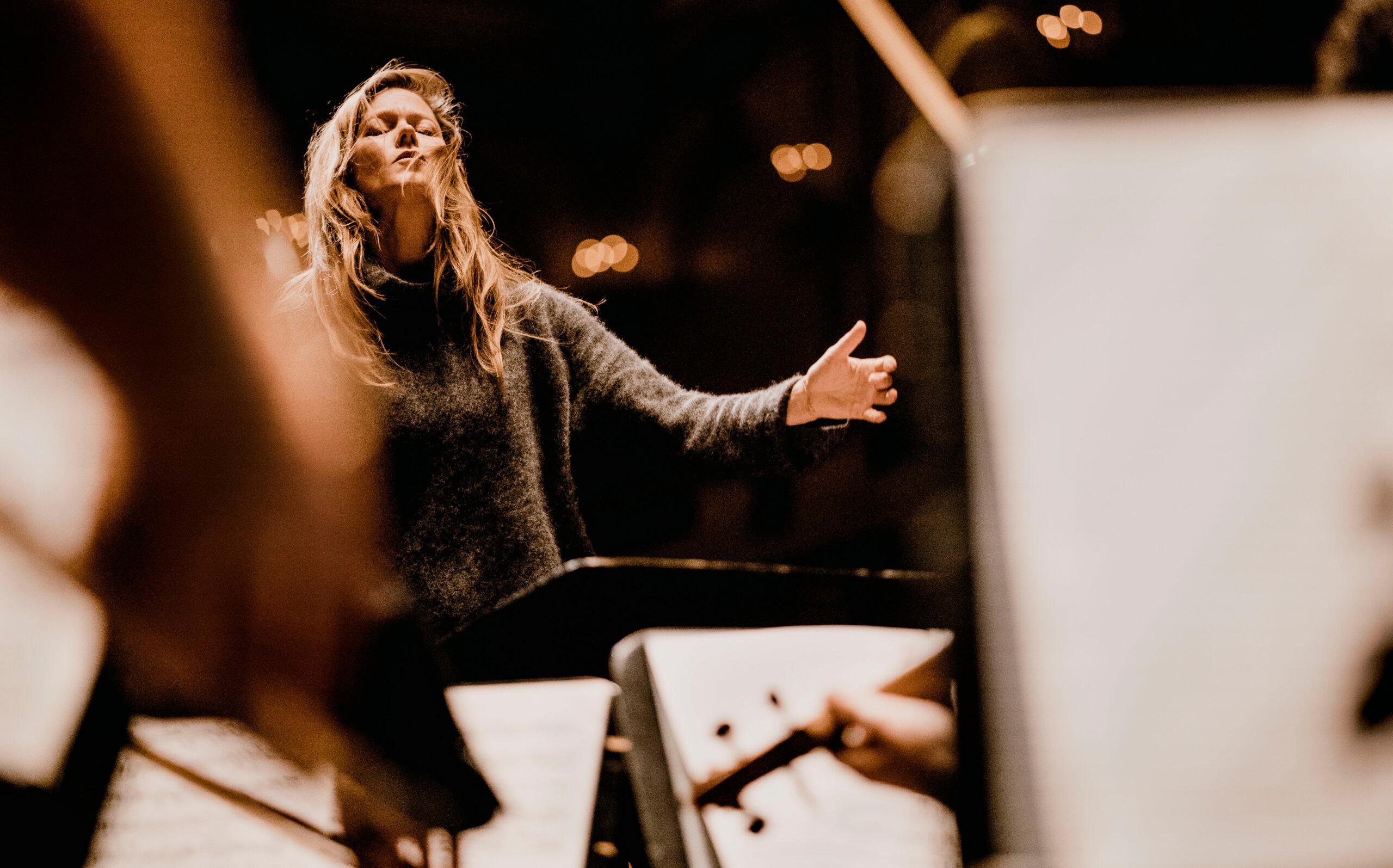 Barbara Hannigan dirigerar i stickad polotröja. Hennes ögon är slutna och håret hänger i testar framför ansiktet.