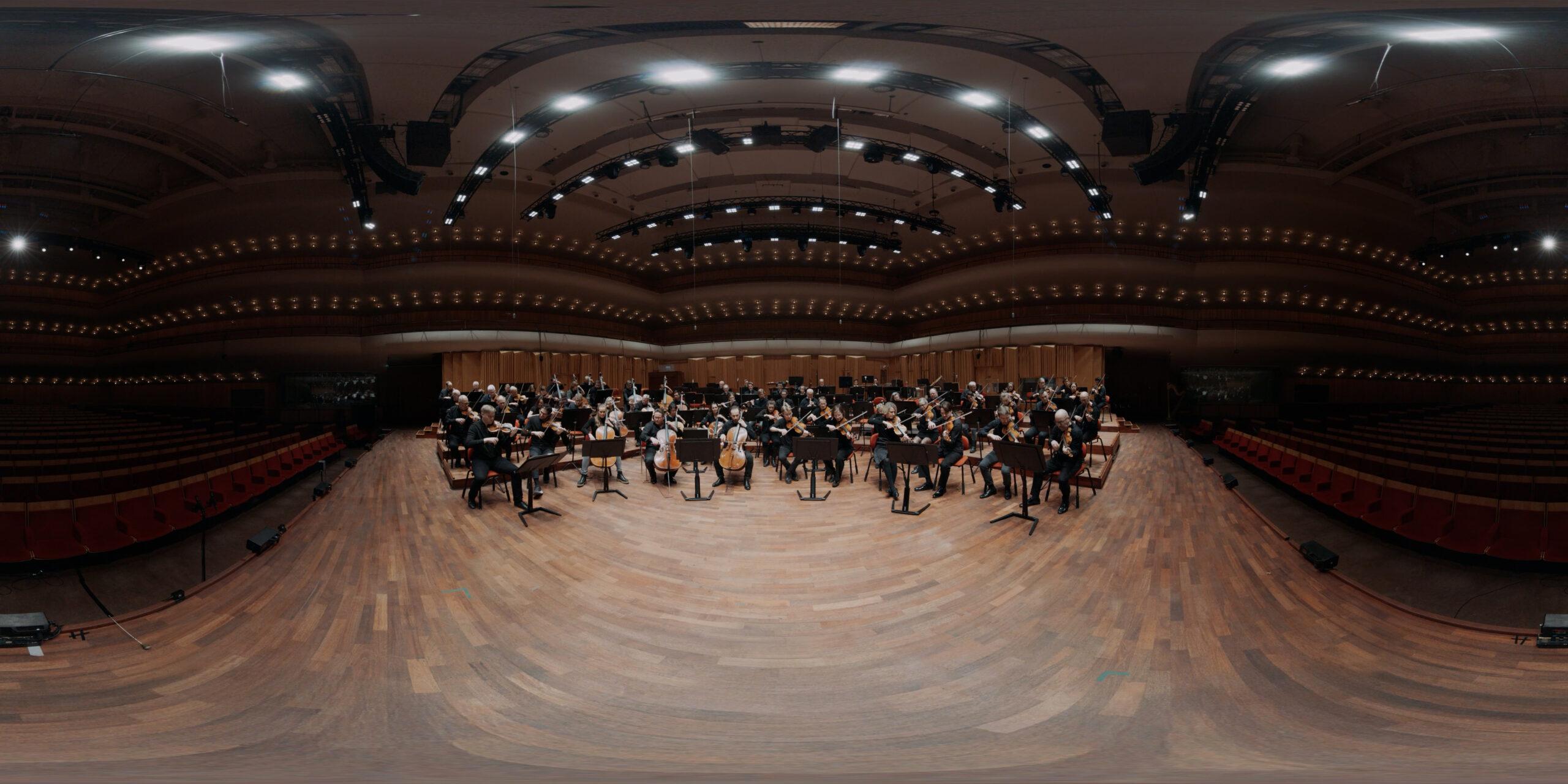 Orkestermusiker på Berwaldhallens scen, sedda ur ett "fish eye lens"-perspektiv.